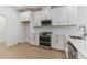 Modern kitchen with white cabinets, stainless steel appliances, and quartz countertops at 18178 Cherished Loop, Bradenton, FL 34211