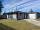 Ranch-style home with gray exterior, attached garage, and well-maintained lawn at 2529 Ednor St, Port Charlotte, FL 33952