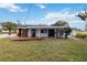 Home's back with a wooden deck and grassy lawn at 6628 Keystone Dr, Sarasota, FL 34231