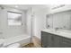 Bathroom with gray vanity, marble-look tile, and bathtub at 6628 Keystone Dr, Sarasota, FL 34231