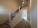 Elegant staircase with dark metal balusters leading to upper level at 7950 Chandler Lake Ct, Hudson, FL 34667