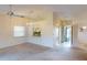 Open living room featuring carpet, a ceiling fan, and a pass-through window to the kitchen, creating a bright and airy space at 1710 Curry Ave # 42, Nokomis, FL 34275