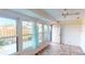 Sunroom with tiled floor, backyard access and light teal curtains at 1710 Curry Ave # 42, Nokomis, FL 34275