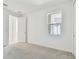 Bright bedroom with neutral carpet, white walls, and a large window at 18024 Cherished Loop, Bradenton, FL 34211