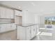 Modern kitchen with island, white cabinets and gray countertop at 18024 Cherished Loop, Bradenton, FL 34211