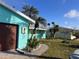 Exterior showcases the home's coastal aesthetic, with vibrant colors and tropical landscaping at 246 176Th E Ave, Redington Shores, FL 33708