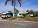 Charming aqua-colored home with well-maintained lawn and tropical landscaping at 246 176Th E Ave, Redington Shores, FL 33708