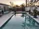 Outdoor pool with brick patio, surrounded by tropical landscaping and a white fence at 246 176Th E Ave, Redington Shores, FL 33708