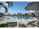 Community pool with zero entry, clubhouse, poolside seating, and palm trees for shade at 4719 Cassonade Cv, Bradenton, FL 34211