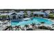 Wide shot of a large community pool with plentiful seating and palm trees at 4719 Cassonade Cv, Bradenton, FL 34211