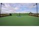 Full basketball court with green surface, dark supports, and tall black lights at a community at 4720 Sweet Retreat Run, Bradenton, FL 34211
