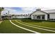 Community pool with a white building, green grass, and palm trees on a sunny day at 4720 Sweet Retreat Run, Bradenton, FL 34211