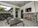 Outdoor fireplace with stone surround, TV, and seating on a patio for cozy community gatherings at 4720 Sweet Retreat Run, Bradenton, FL 34211