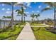 Scenic pathway leading to a playground by a community pool with lush landscaping and palm trees at 7526 Backlight Ln, Sarasota, FL 34240