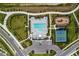 Aerial view of community pool, tennis court, and playground amidst manicured landscaping at 7530 Backlight Ln, Sarasota, FL 34240