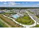Aerial view showcasing a resort-style pool, playground, tennis court, and a lush green dog park at 7534 Backlight Ln, Sarasota, FL 34240