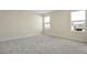 Spacious bedroom with gray carpet and two large windows at 5943 Jensen View Ave, Apollo Beach, FL 33572