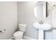 Small bathroom with pedestal sink and circular mirror at 5917 Jensen View Ave, Apollo Beach, FL 33572