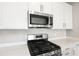 Stainless steel gas cooktop and microwave in a modern kitchen at 5917 Jensen View Ave, Apollo Beach, FL 33572