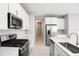 Modern kitchen with white cabinets, stainless steel appliances, and an island at 5917 Jensen View Ave, Apollo Beach, FL 33572