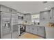 Modern kitchen with gray cabinets, stainless steel appliances, and quartz counters at 407 Belvedere Oval, Temple Terrace, FL 33617