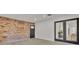 Living room features a brick accent wall, glass doors, and hardwood floors at 407 Belvedere Oval, Temple Terrace, FL 33617