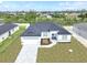 New construction home with gray paver driveway and landscaped yard at 9585 Calumet Blvd, Port Charlotte, FL 33981