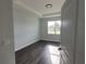 Bright bedroom featuring wood-look floors and a large window at 9585 Calumet Blvd, Port Charlotte, FL 33981