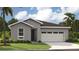 Single-story home with gray exterior, two-car garage, and landscaping at 9049 Players Dr, Weeki Wachee, FL 34613