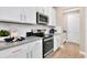 Modern kitchen features gray countertops, white cabinets and stainless steel appliances at 9093 Players Dr, Weeki Wachee, FL 34613