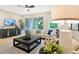 Living room features a comfortable sofa, large windows, and sliding glass doors to patio at 9093 Players Dr, Weeki Wachee, FL 34613