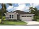 One-story home with gray siding, stone accents, and a two-car garage at 9109 Players Dr, Weeki Wachee, FL 34613