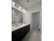 Modern bathroom with dual vanity sinks and dark brown cabinetry at 5046 Avalon Park Blvd, Wesley Chapel, FL 33545