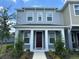 Two-story townhome with gray siding, white trim, and a dark brown door at 5046 Avalon Park Blvd, Wesley Chapel, FL 33545