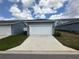 Detached garage with white door and gray exterior at 5046 Avalon Park Blvd, Wesley Chapel, FL 33545