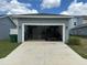 Garage with open door showing home gym inside at 5046 Avalon Park Blvd, Wesley Chapel, FL 33545