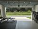 Garage gym with open door view of a tree-lined street at 5046 Avalon Park Blvd, Wesley Chapel, FL 33545