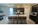 Modern kitchen with dark cabinets, white countertops, and an island with seating at 5046 Avalon Park Blvd, Wesley Chapel, FL 33545