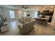 Open living room features a large sectional sofa and an island kitchen with modern pendant lighting at 5046 Avalon Park Blvd, Wesley Chapel, FL 33545