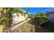 Landscaped backyard with a side walkway and fence at 13 Pebble Beach Rd, Rotonda West, FL 33947