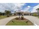 House exterior features a large driveway and manicured lawn at 13 Pebble Beach Rd, Rotonda West, FL 33947