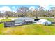 Large backyard with a deck, hot tub, screened porch, and detached garage on a well-maintained lawn at 8600 W Knights Griffin Rd, Plant City, FL 33565
