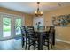 Bright dining room features patio access, a modern chandelier, and seating for six at 8600 W Knights Griffin Rd, Plant City, FL 33565