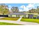 Charming single-story home featuring a well-manicured lawn, fresh exterior paint, and lush landscaping at 8600 W Knights Griffin Rd, Plant City, FL 33565