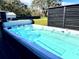 Outdoor spa featuring a swim spa with black privacy fence and backyard views at 8600 W Knights Griffin Rd, Plant City, FL 33565