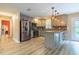Open kitchen showcases stainless appliances, light gray cabinets and marble counters with bar seating at 8600 W Knights Griffin Rd, Plant City, FL 33565