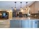 Modern kitchen featuring stainless steel appliances, sleek gray cabinetry, and attractive pendant lighting at 8600 W Knights Griffin Rd, Plant City, FL 33565