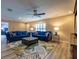 Stylish living room featuring bright blue sofas, a modern ceiling fan, and an airy open layout at 8600 W Knights Griffin Rd, Plant City, FL 33565