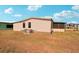 View of home's backyard with green grass and beige siding at 313 Mariner Dr, North Port, FL 34287