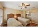Bedroom featuring two beds, wood-look floors, a ceiling fan, and a mirrored closet at 313 Mariner Dr, North Port, FL 34287